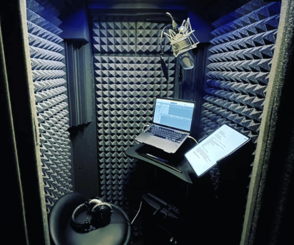 Inside look at Josh Robert Thompson's vocal booth showing a laptop, mic, and other recording tools.
