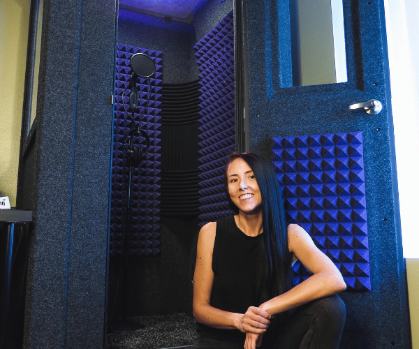 Michele Whitlow sitting next to her portable vocal booth.