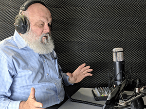 man with gray beard recording his voice