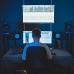 a recording engineer sitting in a chair looking at his computer monitor