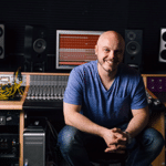Justin Cortelyou sitting in front of his studio's mixing board