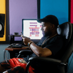 man sitting at desk in home recording studio