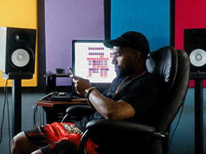 man sitting at desk in home recording studio