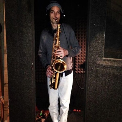 A man playing saxophone inside of his WhisperRoom practice booth