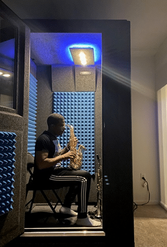 Musician Antonia Hart getting ready to play saxophone inside of his WhisperRoom sound booth.