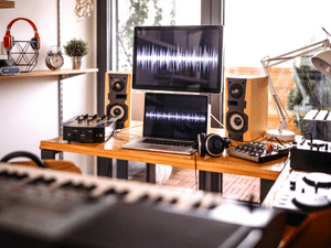 A home recording studio with monitors, speakers, and other various recording gear