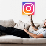 Man listening to music on the couch while holding the Instagram logo