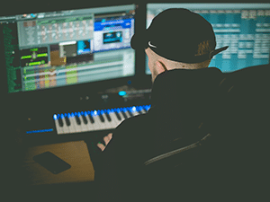 A music producer working on a song file on the computer.