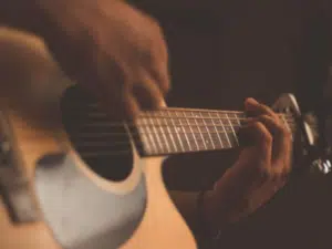 Chords being played on an acoustic guitar with a capo