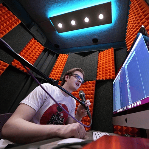 A student at GCU recording a podcast inside of their WhisperRoom MDL 7296 E sound booth.