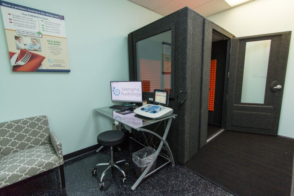 A WhisperRoom audiometric booth shown next to testing equipment in an office at Memphis Audiology.