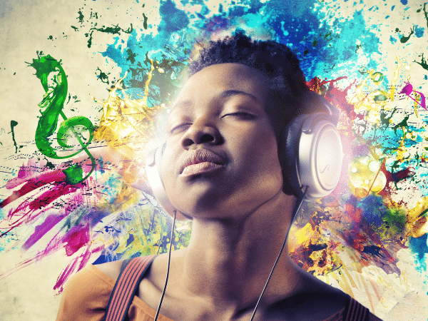 A young woman listening to music with headphones on and eyes closed.
