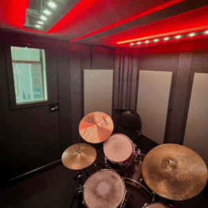 Drum Kit Inside WhisperRoom's Drum Booth Package: Enhanced with Red LED Studio Lights, Acoustic Panels, and Bass Traps for Optimal Sound Isolation and Acoustic Performance.