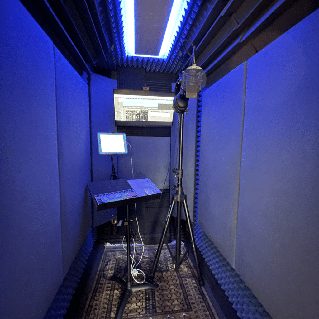 Interior of WhisperRoom Vocal Booth with Studio Foam, LED Studio Light, Mic, and Recording Setup.
