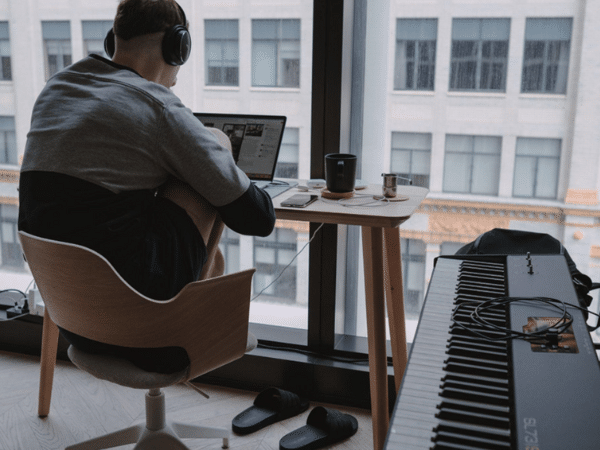 Man in Recording Studio with Headphones and Laptop - Exploring Music Promotion Through Digital Content