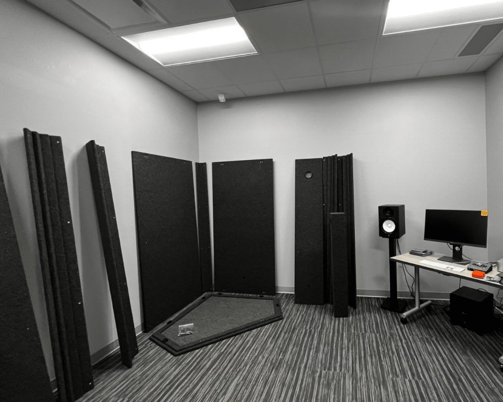 Photograph portraying WhisperRoom components neatly staged against a wall, showcasing their readiness for assembly. This image exemplifies the ease of assembling a WhisperRoom within an existing space.