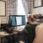 Music producer sitting at her desk, registering the copyright of her song on a computer, illustrating intellectual property protection for musicians.